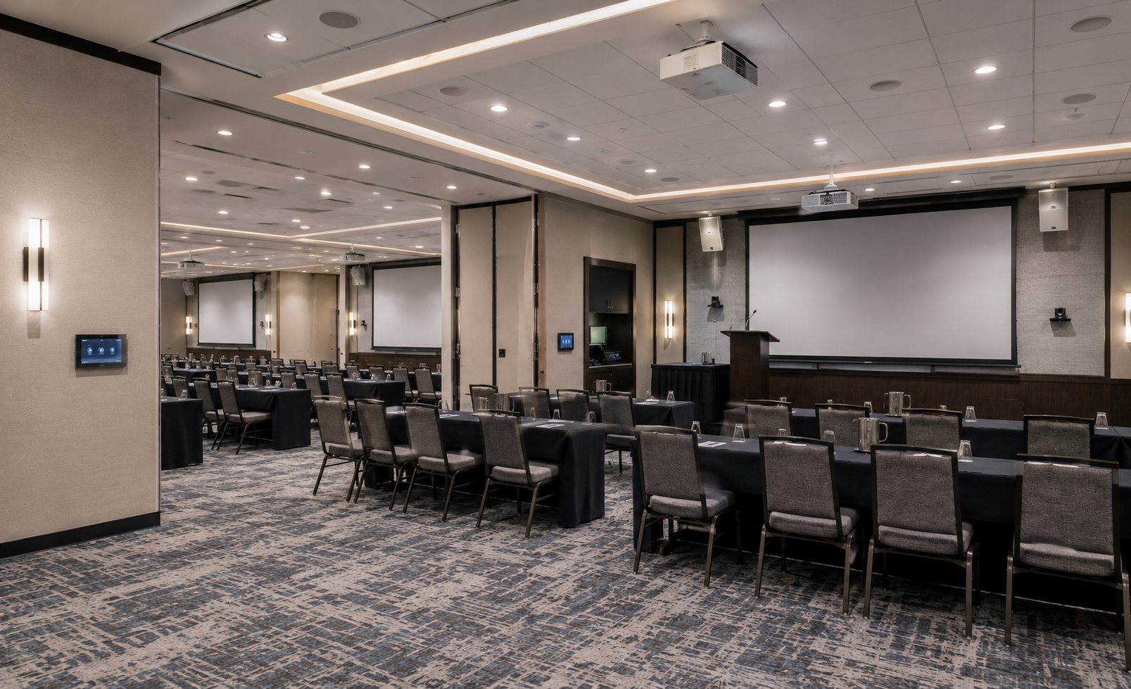 Hotel conference room with projectors, screens, speakers, and AV controls