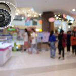 High-resolution dome security camera monitoring busy retail shopping area with customers and storefronts — professional retail surveillance system installed by Apollo Technology & Cabling